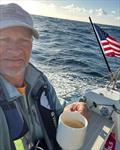 Nico sailing on Pegasus 50 - coffee and flag