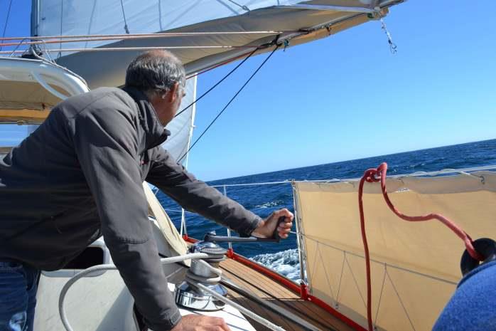 Captain sheeting the head sail on passage - photo © Maree & Phil