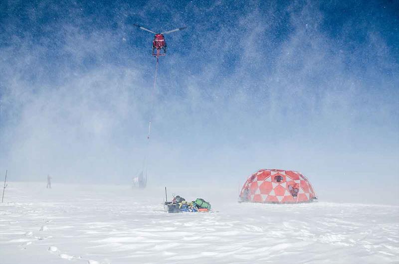 An Air Greenland AS350 helicopter takes off from the ice cap drilling camp, at 2000-m elevation on top of the Nuussuaq Peninsula, with a sling-load of precious ice core cargo.  - photo © Sarah Das, Woods Hole Oceanographic Institution