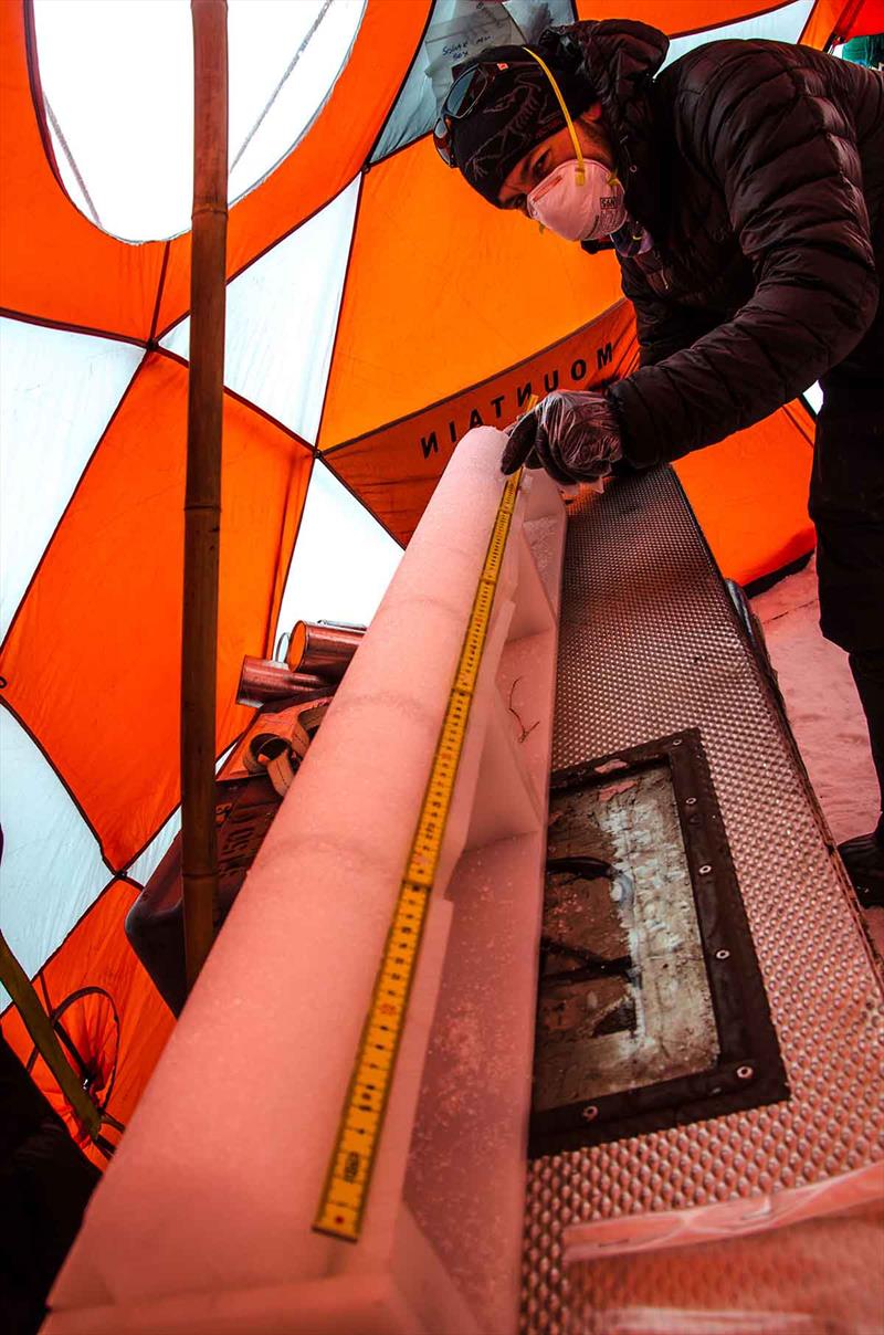 Study lead author and WHOI post-doc Dr. Luke Trusel (now at Rowan University) takes field measurements of a section of ice core from Greenland before packing it for transport home photo copyright Sarah Das, Woods Hole Oceanographic Institution taken at  and featuring the Cruising Yacht class