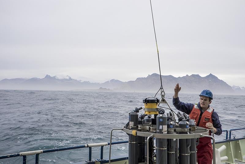 WHOI Postdoctoral researcher Nick Foukal helps deploy an instrument package that takes physical measurements of the water column off the coast of Greenland from aboard the R/V Knorr. - photo © Carolina Nobre, Woods Hole Oceanographic Institution