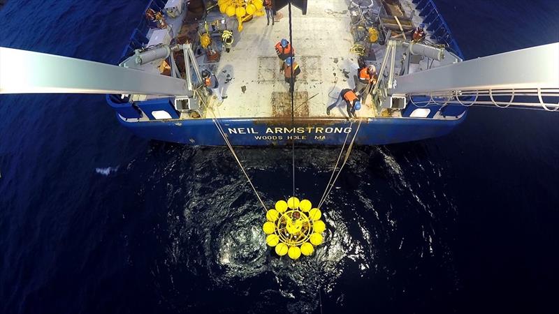 The crew aboard the R/V Neil Armstrong  deploy a package of instruments mounted on a tripod near the coast of Greenland. This package sits on the seafloor out of harm's way from the dozens of icebergs that go over it each year. - photo ©  Joseph McCabe, Woods Hole Oceanographic Institution