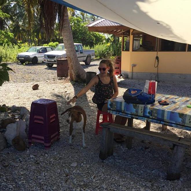 Camille of SV Anila doing school work ashore at Pakakota while Dad fixed the broken water maker. Bonus was petting the owner's dog - photo © Henk and Lisa Benckhuysen