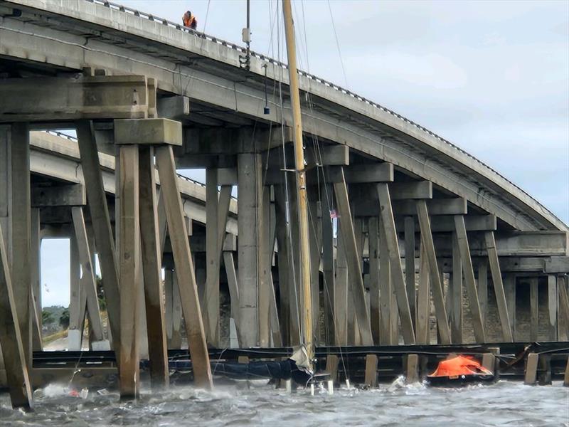 This unfortunate sailboat, life raft deployed, was blown onto a nearby bridge during Nicole. This boat was anchored in the river and dragged. “Slowpoke” and “Flow” were tied in a safer place, the mangroves of the Canaveral Barge Canal, and did not drag - photo © Jan Pehrson