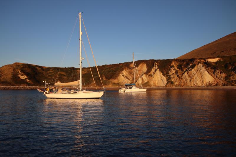 Coruisk and a catamaran in the dawn light in Warbarrow Bay - photo © Reg Barker