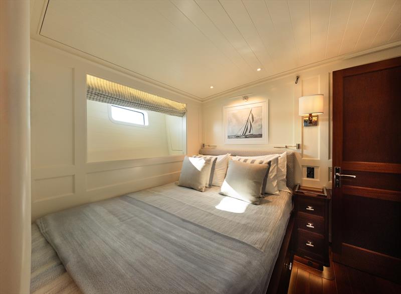 Ouzel, a 95ft superyacht - A guest stateroom aboard Ouzel pairs softly upholstered finishes with warm mahogany joinery - photo © Russell Kaye