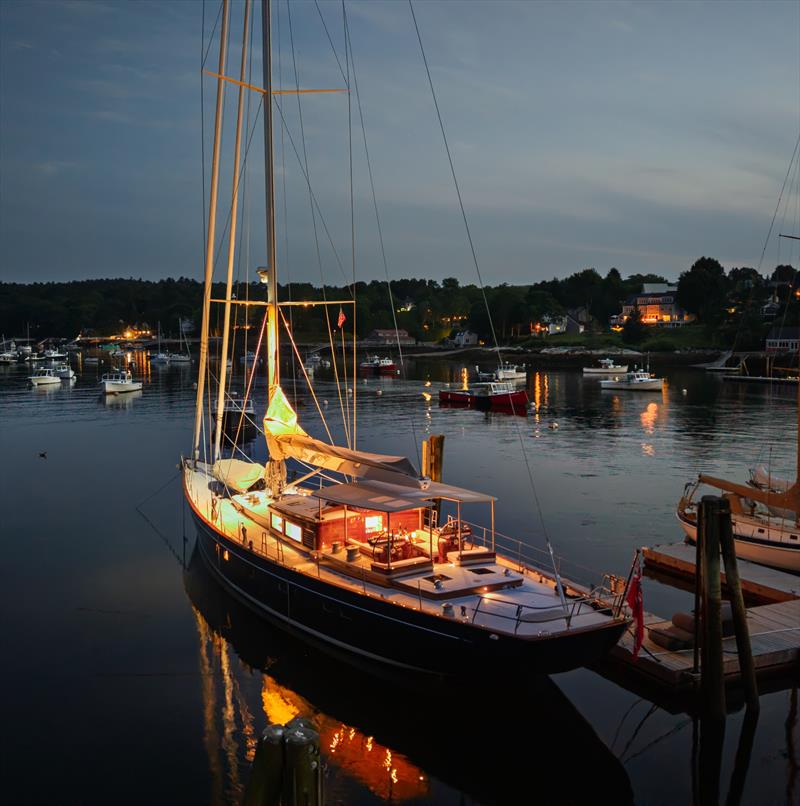 Ouzel's deck and pilothouse glow against the evening waters of Rockport Harbor - photo © Russell Kaye