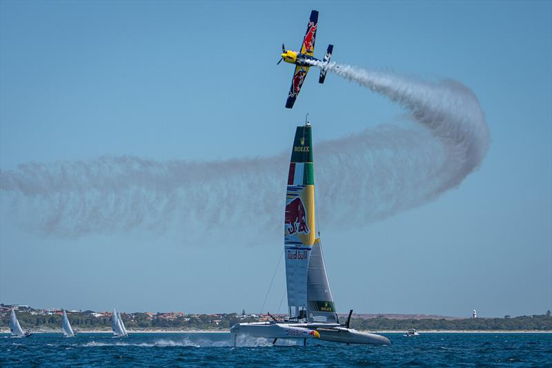 A Red Bull stunt aeroplane flies close to the Red Bull Italy SailGP Team F50 catamaran during a practice session ahead of the ORACLE Perth Sail Grand Prix in Perth, Australia - photo © SailGP / Red Bull Content Pool