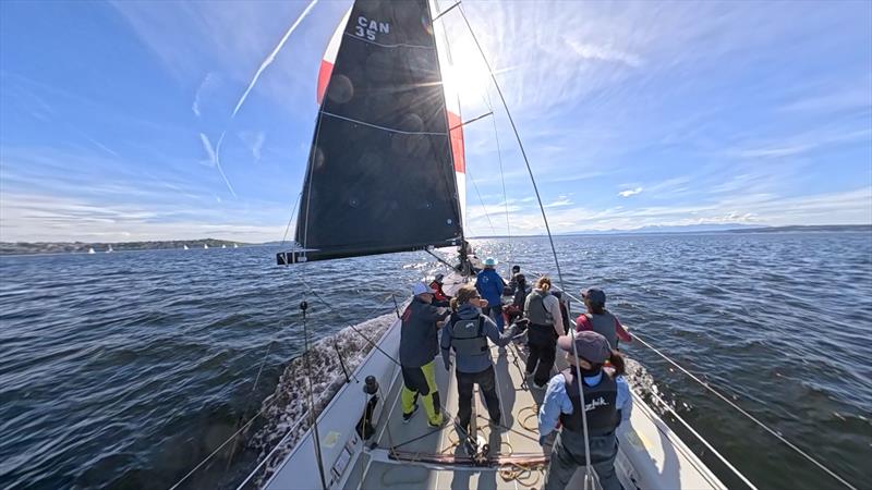 Jonathan McKee (left, in yellow bibs) discusses downwind breeze with Jen Glass (second from left), Cascadia Sailing's tactician - photo © Cascadia Sailing Collection