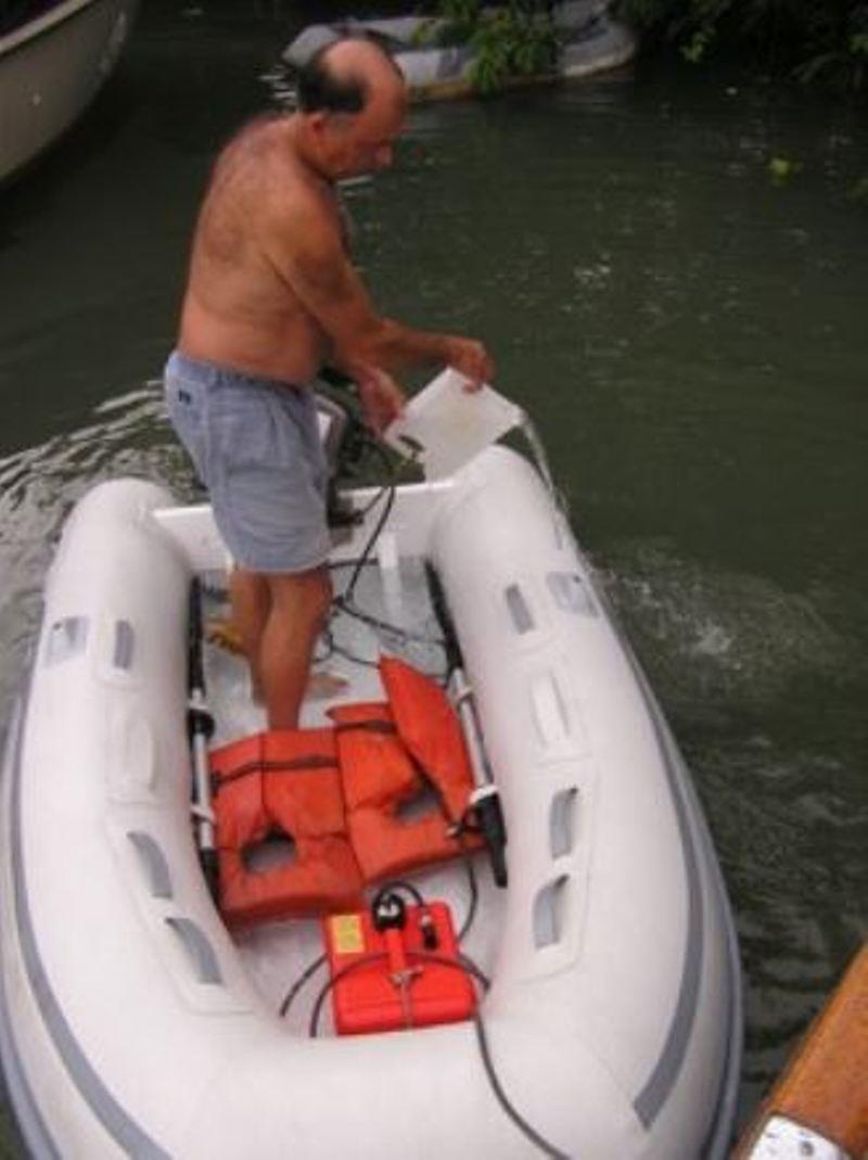 Gas can locked in dinghy, David's Bailing a tropical downpour - photo © Commuter Cruiser
