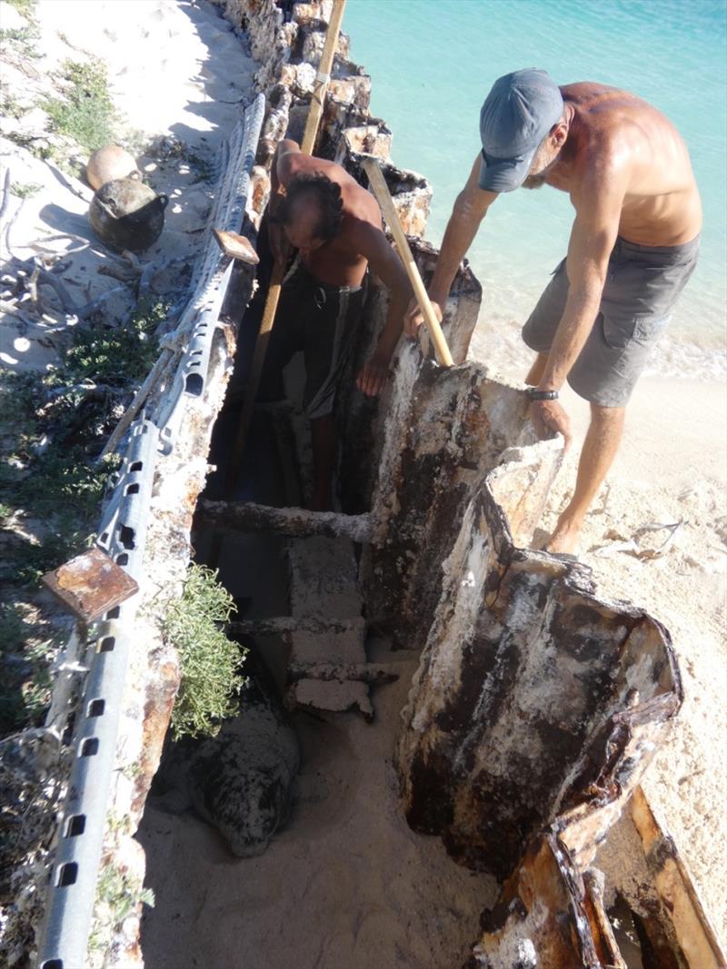 Two researchers determine how best to rescue a Hawaiian monk seal pup after the pup became trapped within the narrow confines of a degrading double seawall on Tern Island. - photo © NOAA Fisheries