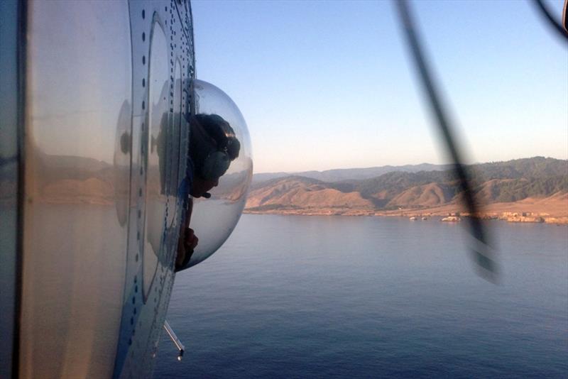 A biologist from NOAA Fisheries' Southwest Fisheries Science Center watches through a special bubble window of the survey plane for marine life below. - photo © Scott Benson / NOAA Fisheries