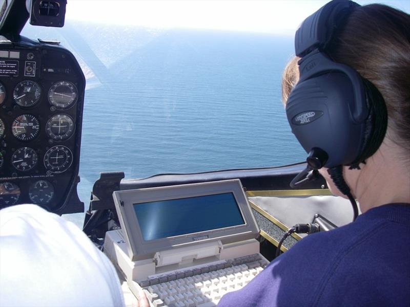 Research biologist Karin Forney of the Southwest Fisheries Science Center enters survey data into a computer aboard the airplane. - photo © Scott Benson / NOAA Fisheries