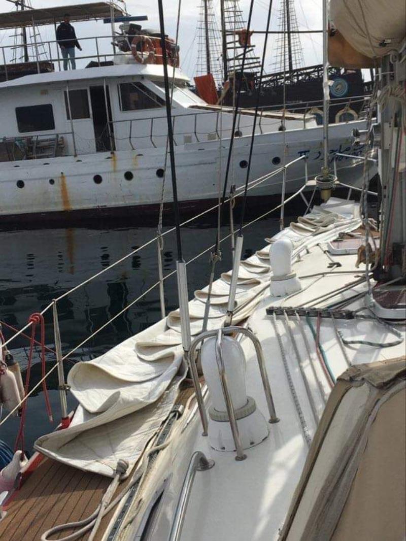 Head sail coming off (being folded on deck) for inspection and to keep them out of the UV and red rain (desert sand) for winter - photo © SV Red Roo