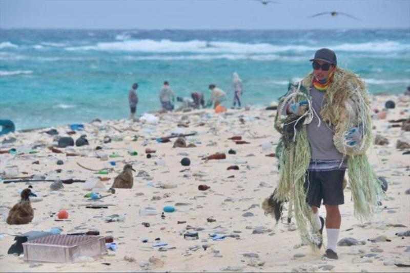 The Pacific Islands Fisheries Science Center Marine Debris Project Lead, James Morioka, removes marine debris from the shorelines of Kamole (Laysan Island) in March 2021. - photo © Papahanaumokuakea Marine Debris Project / Matthew Chauvin