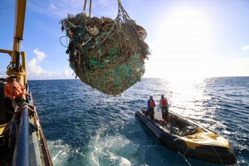 NOAA Coxswain Ariel Halperin and Papahanaumokuakea Marine Debris Project's Kevin O'Brien crane a large load of derelict fishing nets removed from Kamokuokamohoalii (Maro Reef). - photo © NOAA Fisheries / James Morioka
