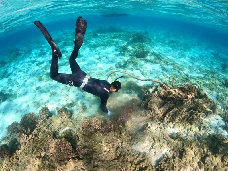 James Morioka carefully removes a derelict fishing net from the reef at Holaniku (Kure Atoll). - photo © NOAA Fisheries / Ariel Halperin