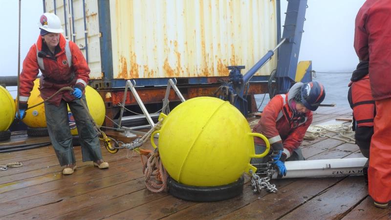 NOAA Fisheries scientists Jessica Crance (left) and Stephanie Grassia assemble mooring equipment for deployment in the Bering Sea. The acoustic recorder is in the white tube. - photo © NOAA Fisheries