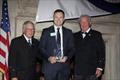 Peter Gibbons-Neff Jr., receives the 2025 Charles H. Vilas Literary Prize, with the incoming CCA Commodore Chace Anderson, left, and outgoing CCA Commodore Jay Gowell &copy; Guy Gurney