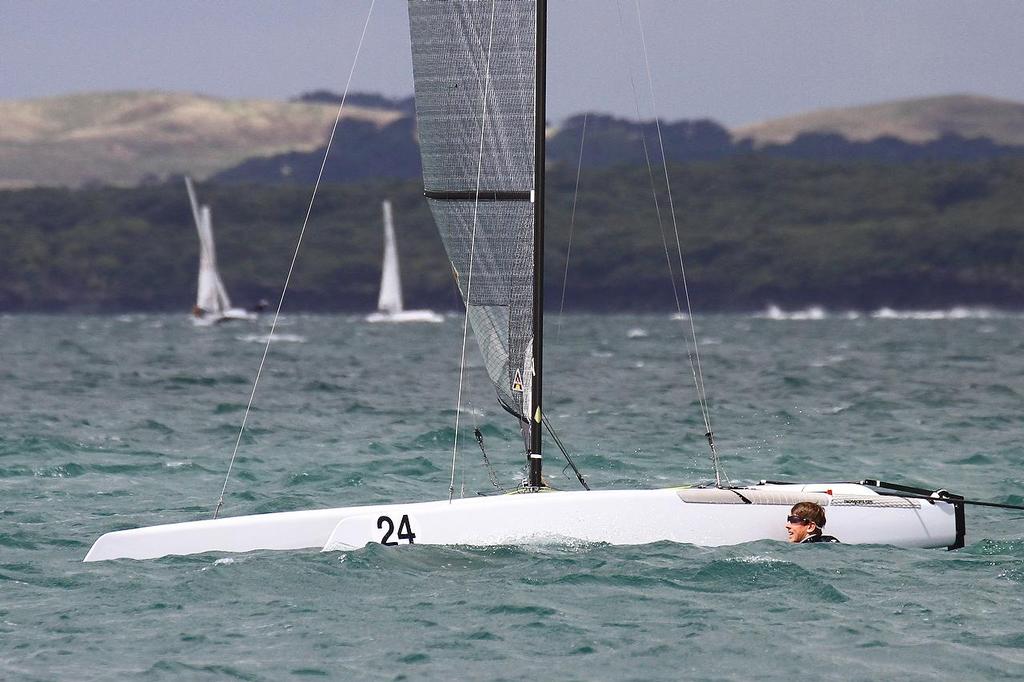 Peter Burling (NZL) swimming in Race 6, final leg, trying to clear a foil issue. A-class catamaran World Championships, Day 3, Takapuna February 13, 2014 © Richard Gladwell www.photosport.co.nz