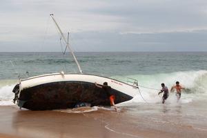 A group of bystanders attempt, unsuccessfully, to manoeuvre the yacht back into the water at Stanwell Park Beach on Sunday. photo copyright Sylvia Liber taken at  and featuring the  class