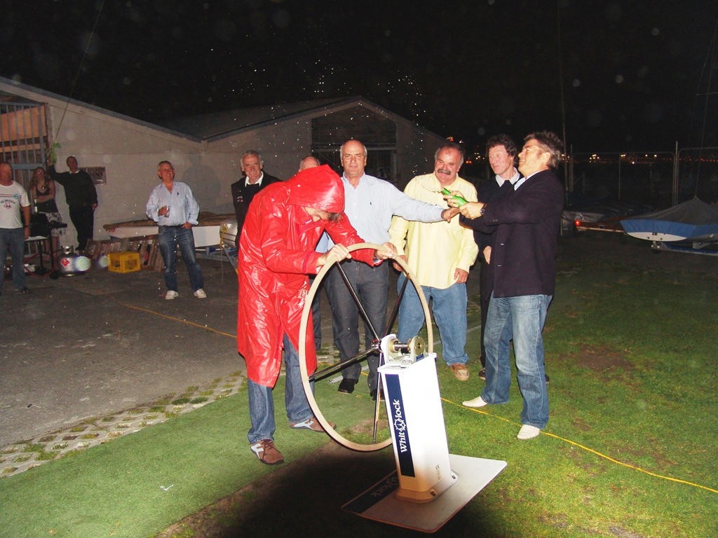 Owen Rutter, replete in his Ceramco wet weather gear, takes his position at the wheel with Richard White providing the 