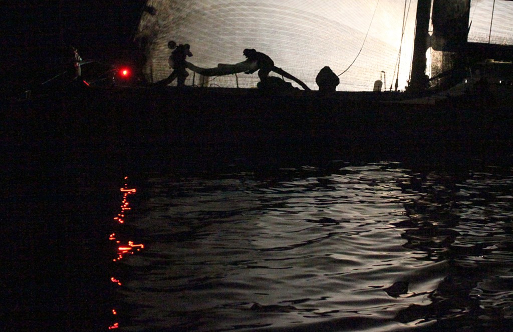 Loyal Investec foredeck crew prepare a new sail as she drifts in the Derwent River, barely two miles from the finish - Rolex Sydney Hobart Yacht Race 2010 © Crosbie Lorimer http://www.crosbielorimer.com