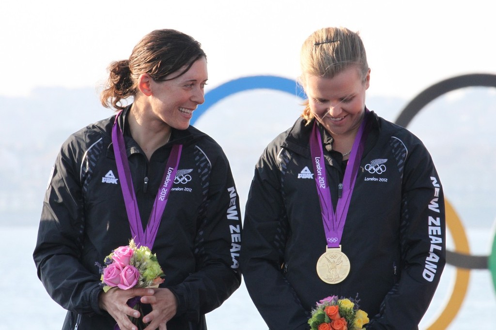  August 10, 2012 - Weymouth, England - Jo Aleh and Olivia Powrie share a thought be the raising of the new Zealand flag at Weymouth © Richard Gladwell www.photosport.co.nz