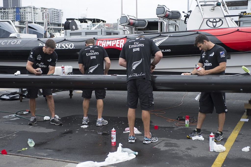 Emirates Team New Zealand sailors Derek Seward, Tony Rae, Rob Waddell and Jeremy Lomas clean up a beam from AC72 number 1 to be fitted to the teams second AC72. 15/1/2013 © Chris Cameron/ETNZ http://www.chriscameron.co.nz