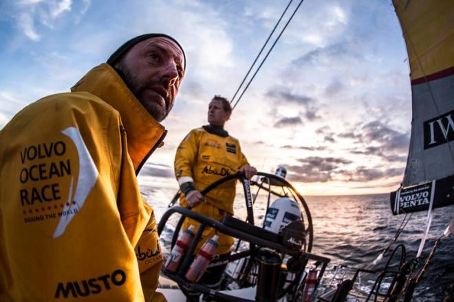 Leg 7 to Lisbon onboard Abu Dhabi Ocean Racing. Day 3. A backlit Ian Walker eyes the sail trim as Luke 