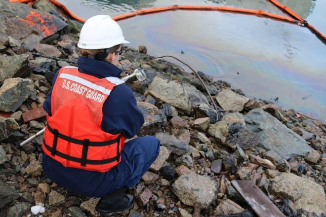 Petty Officer 1st Class Ann Marie Borkowski collects a sample of the heavy fuel oil discharged into Boston Harbor during the wreck removal of the ferry Peter stuyvesant on Feb. 15, 2017. The ferry is being excavated as a part of a major redevelopment project at Pier 4. © Petty Officer 2nd Class Jonathan Clough