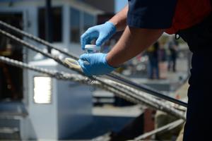 Petty Officer 3rd Class John Northup screws on the lid to a sample jar in New Bedford Harbor, Massachusetts, Tuesday, May 16, 2017. Samples from suspected bilges are documents and taken to the Coast Guard Marine Safety Lab in New London, Connecticut for testing photo copyright  Nicole J. Groll taken at  and featuring the  class