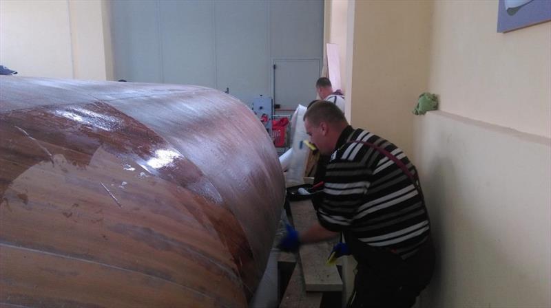 Croatian Gajeta build - the team first roll on a coat of Epoxy onto the bare wooden surface - photo © West System International